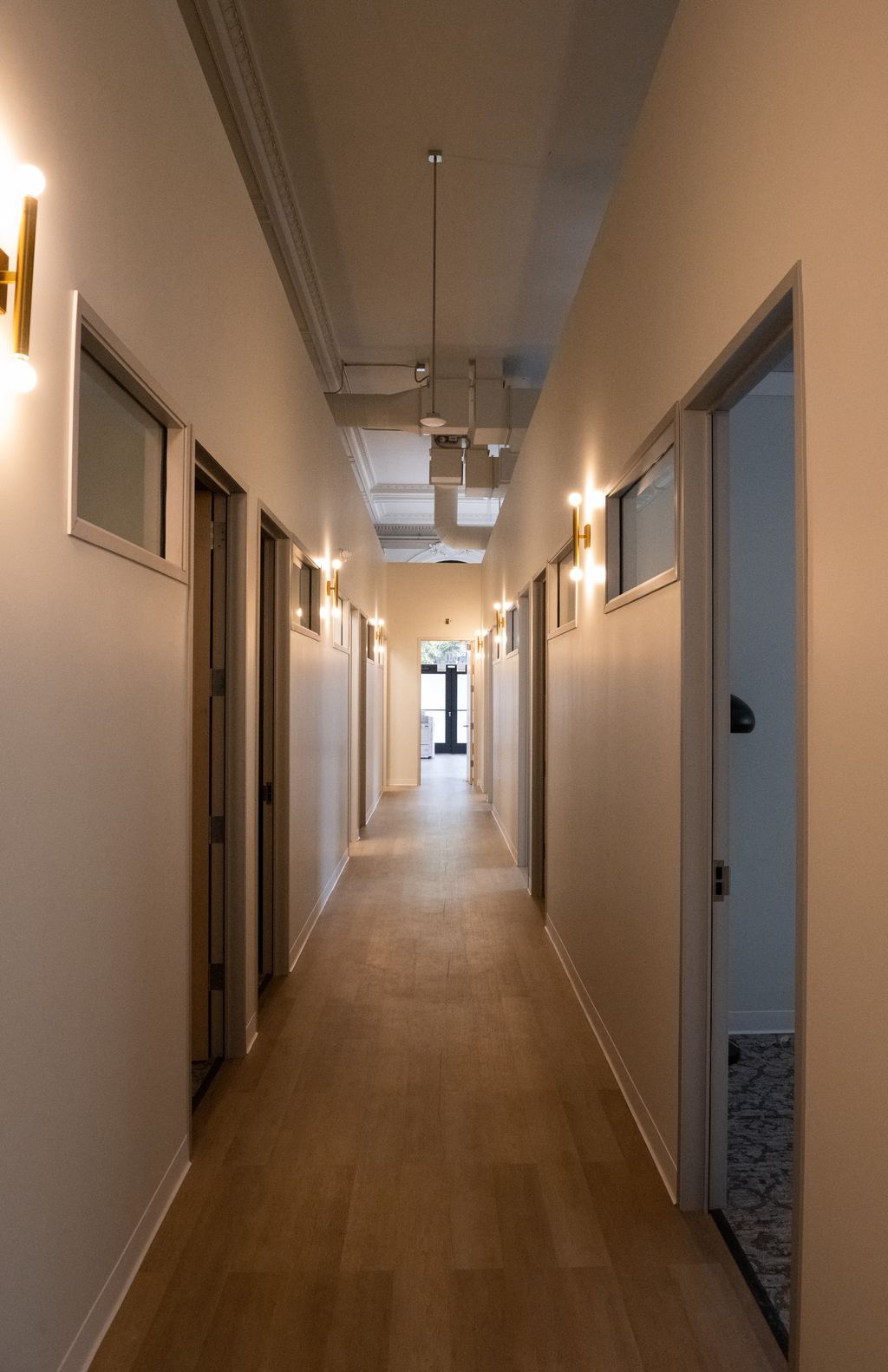Corridor with new oak flooring, brass sconces and clerestory glass
