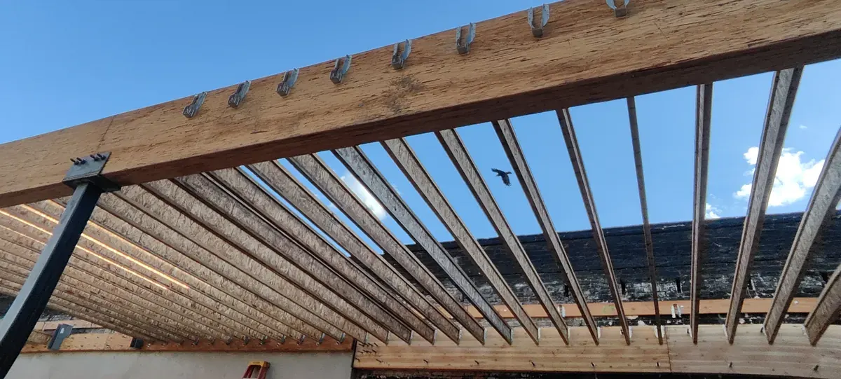 New roof joists framed on steel before sheathing, Bluxome St fire-loss rebuild