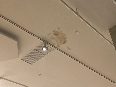 Commercial restroom with water-damaged ceiling, before repair