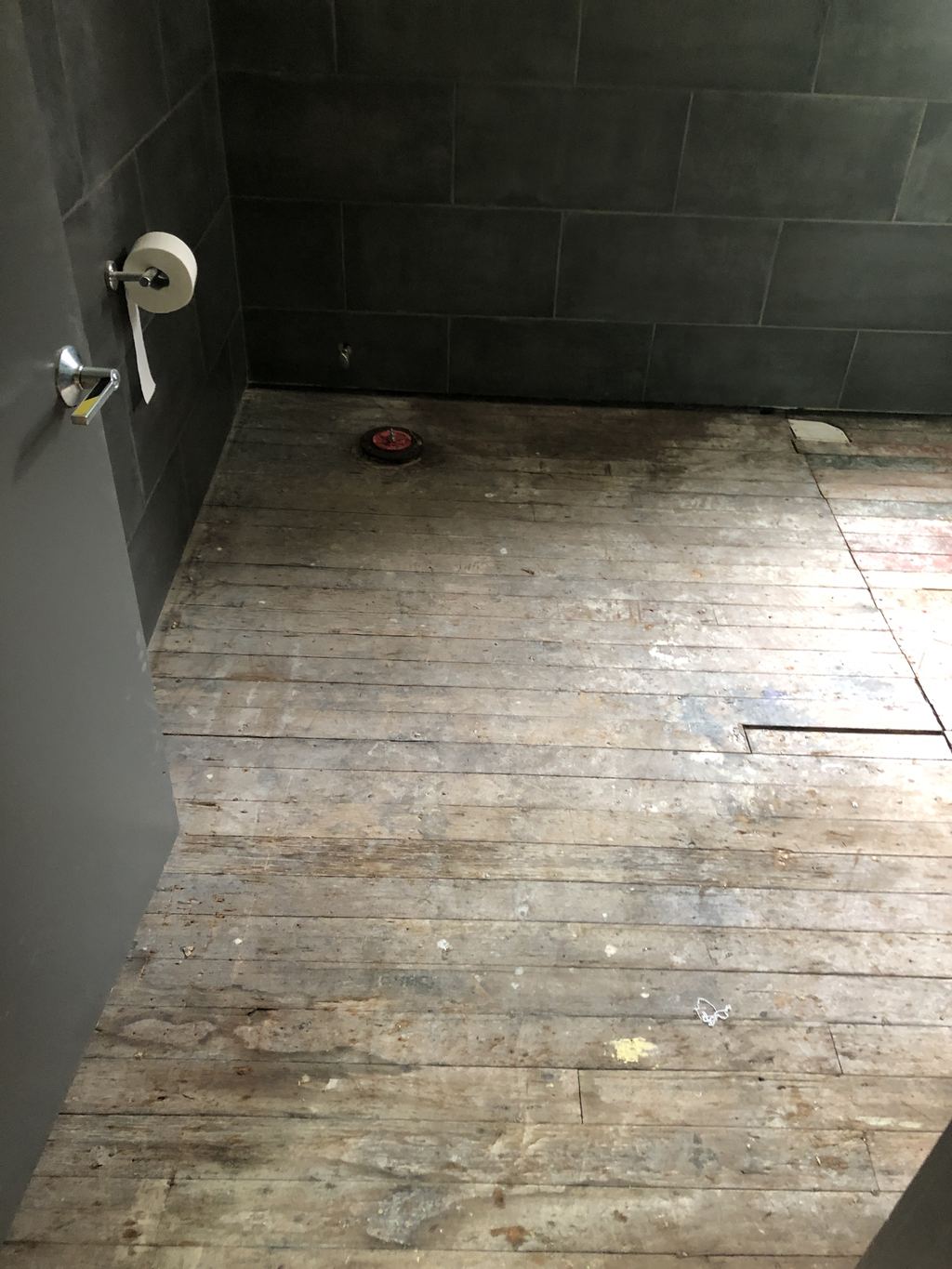 Before: restroom floor opened up to the original boards after a water leak